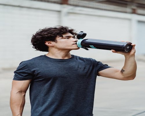 active man drinking water after light exercise outdoor